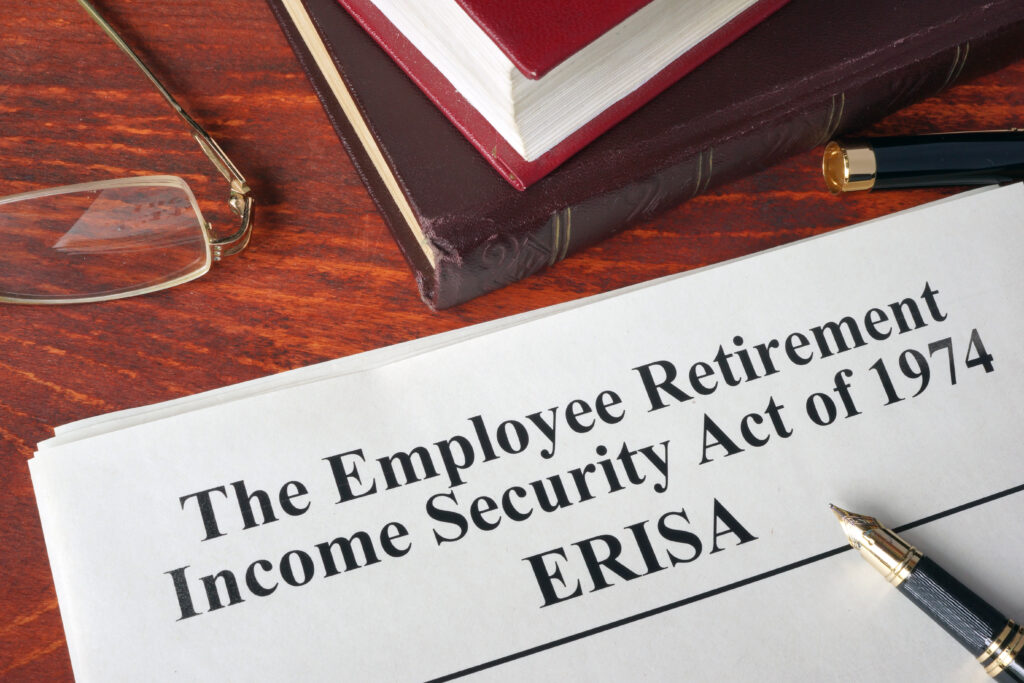 Document of The Employee Retirement Income Security Act of 1974 – ERISA. A pen and glasses are next to the document on the table. 