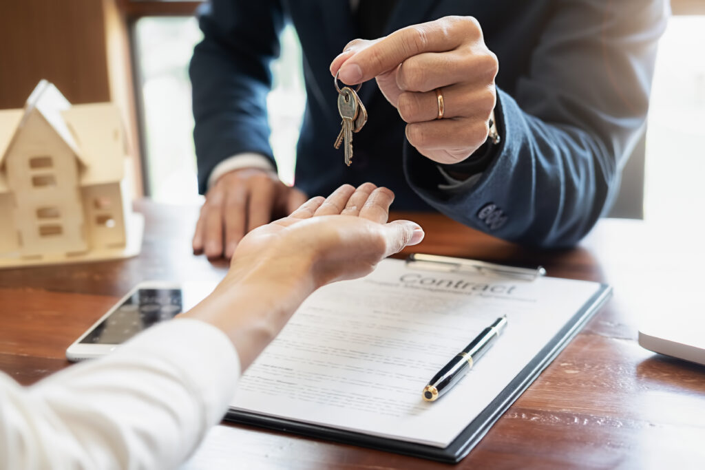Self-Directed IRA LLC account holder being given the keys to a real estate investment after signing a contract.