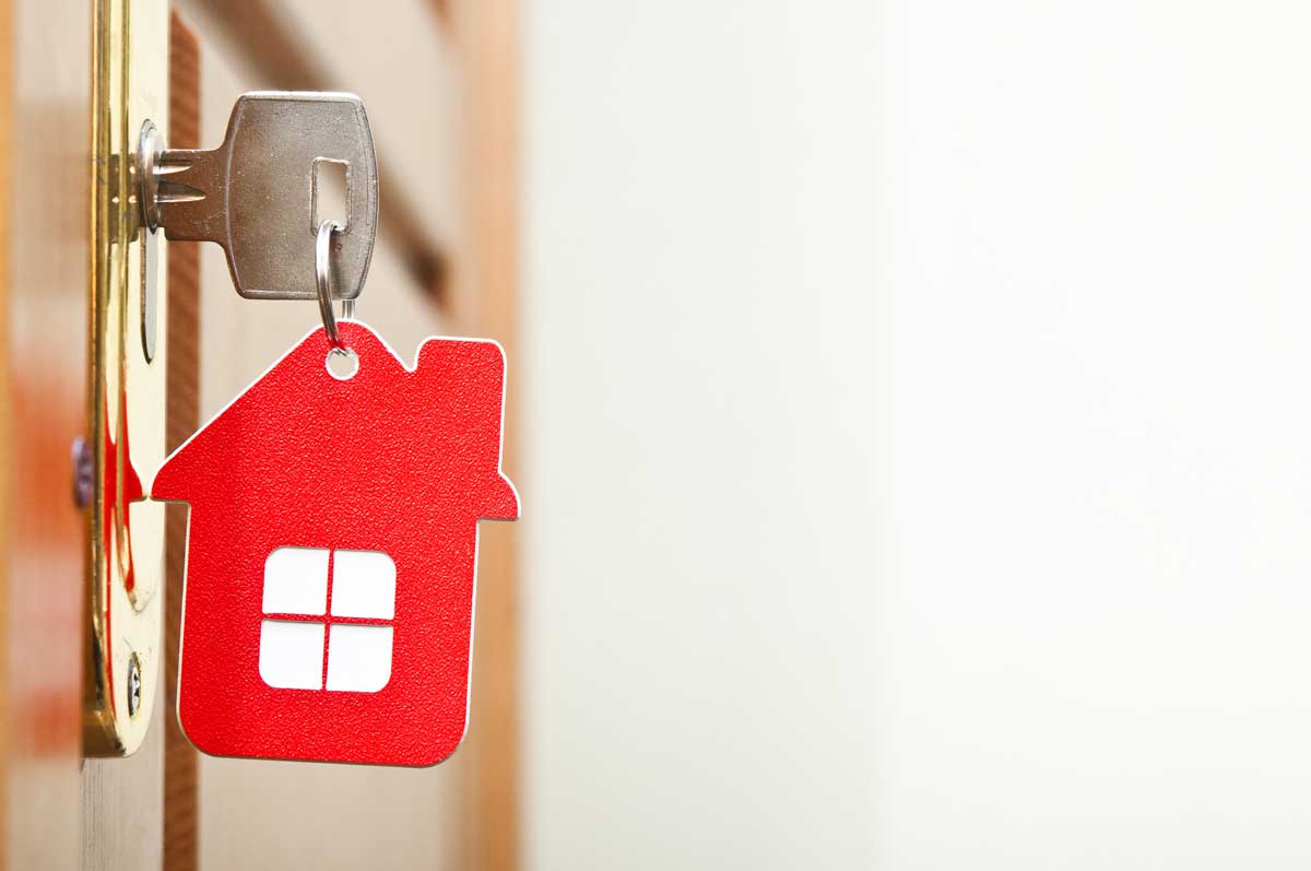 Real estate investment key with a red house as the keychain in a door’s lock to show how a non-recourse loan can help Self-Directed Checkbook IRA account holder acquire a real estate investment.
